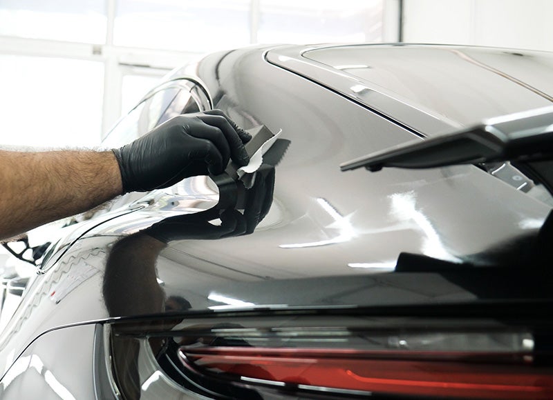 Technician coating car exterior